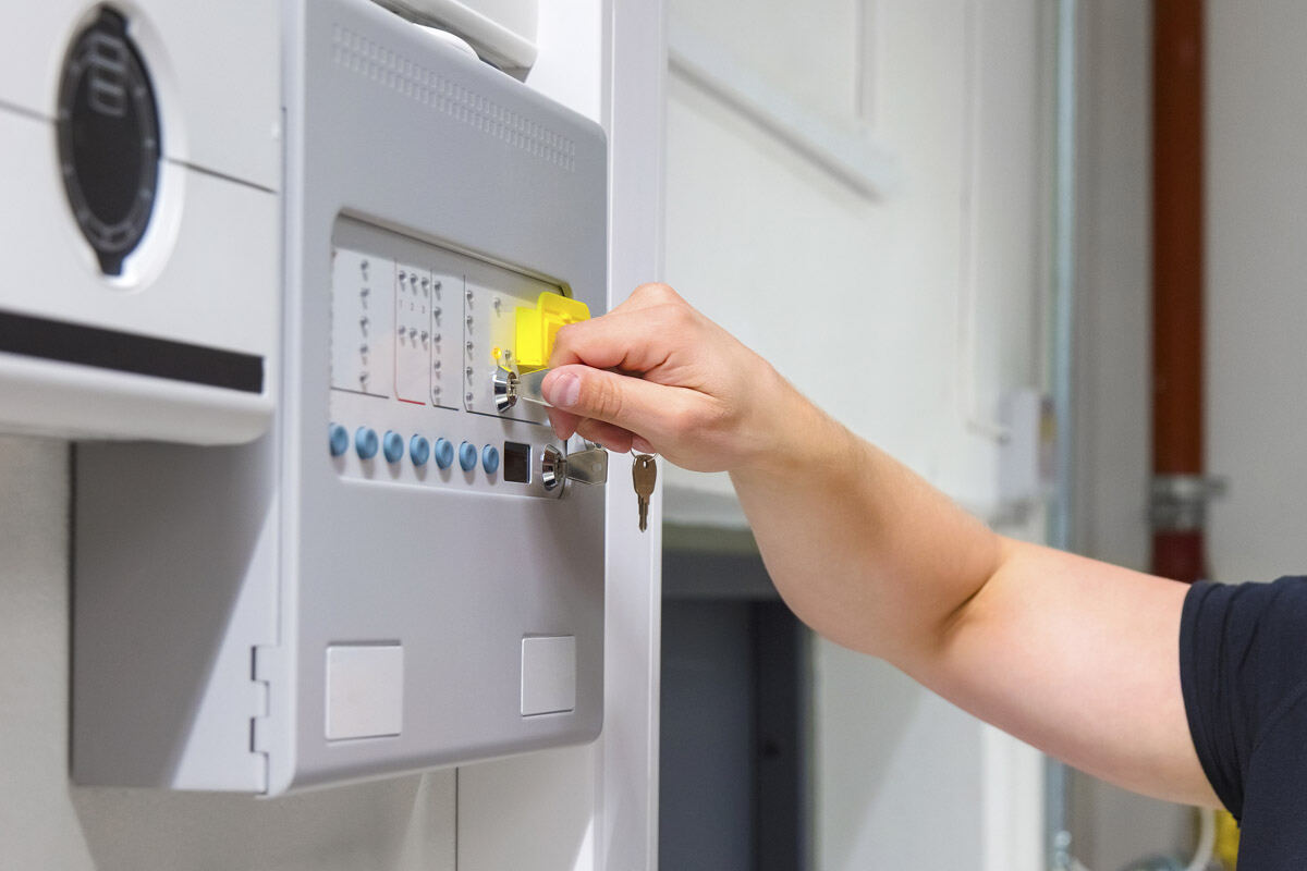 Engineer resetting a fire alarm control panel