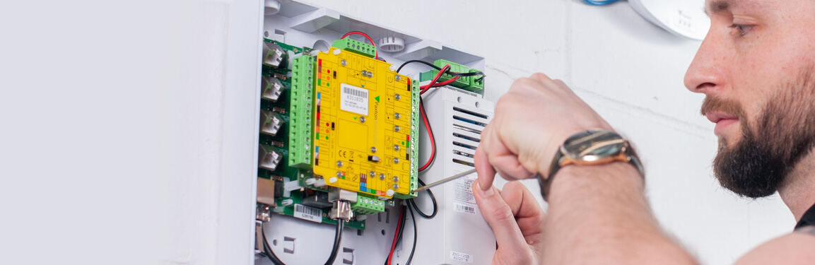 Engineer fitting a Paxton access control unit